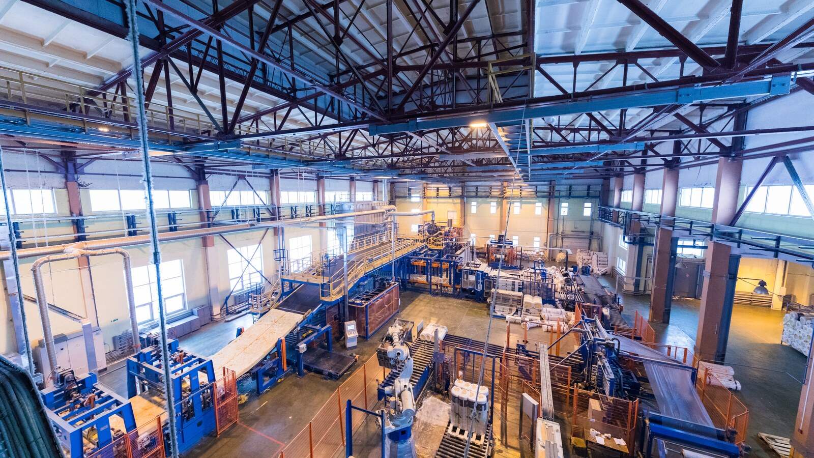 Vista elevada de una nave de producción con varias líneas, máquinas y pasarelas